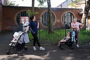 mothers chatting in front of a peace wall gate at Duncairn gardens